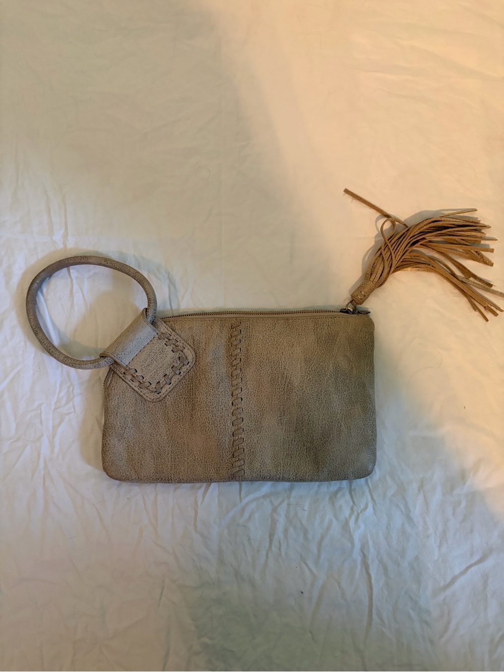 HOBO Sable wristlet in a tan/gold color with tassel